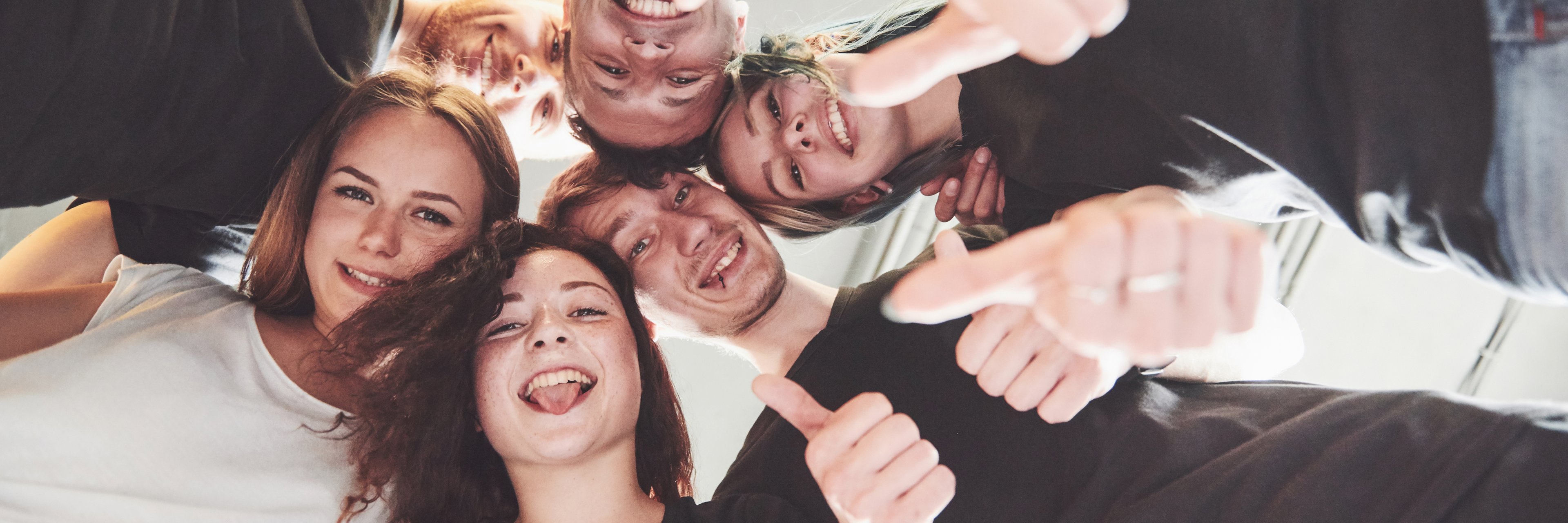 Happy group of friends with their hands together in the middle